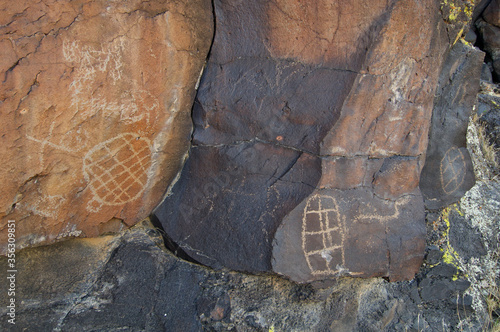 Different degrees of patination on rock surface and petroglyphs, Mojave National Preserve, California. Unfortunate graffiti too