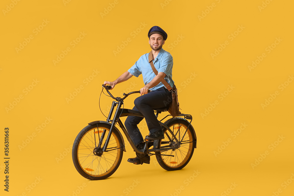 Handsome young postman with bicycle on color background Handsome young postman with bicycle on color background