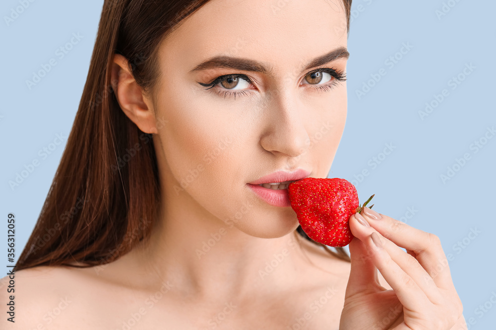 Sexy young woman with strawberry on color background Sexy young woman with strawberry on color background