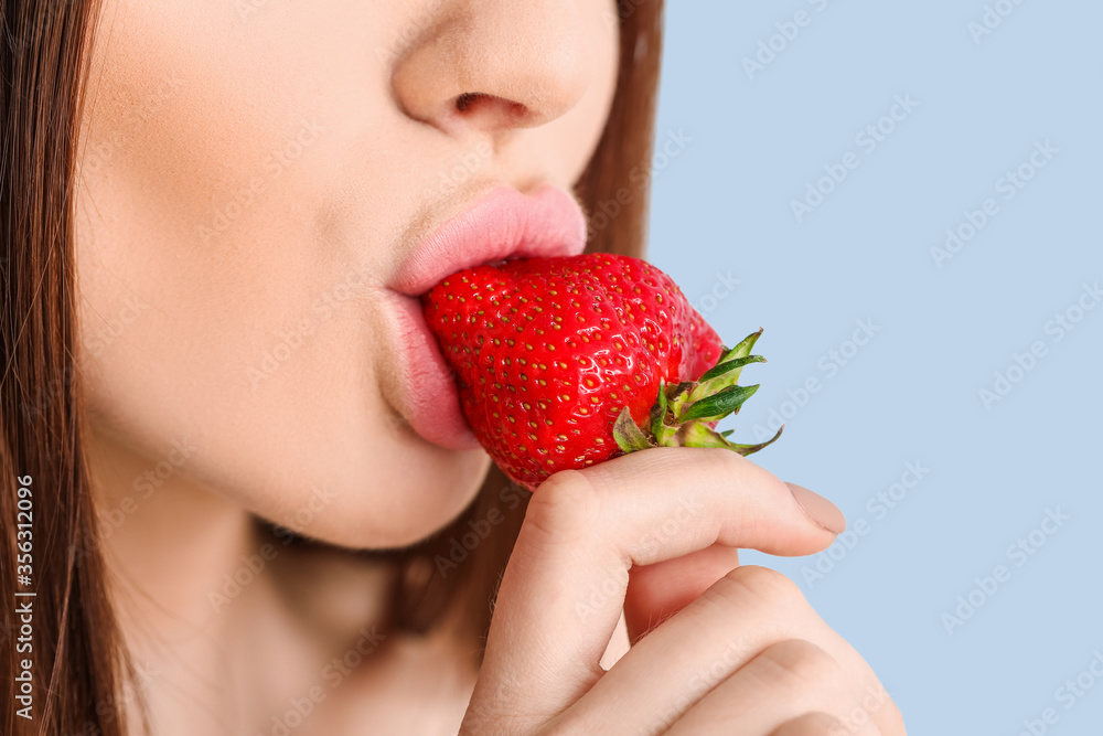 Sexy young woman with strawberry on color background, closeup Sexy young woman with strawberry on color background, closeup
