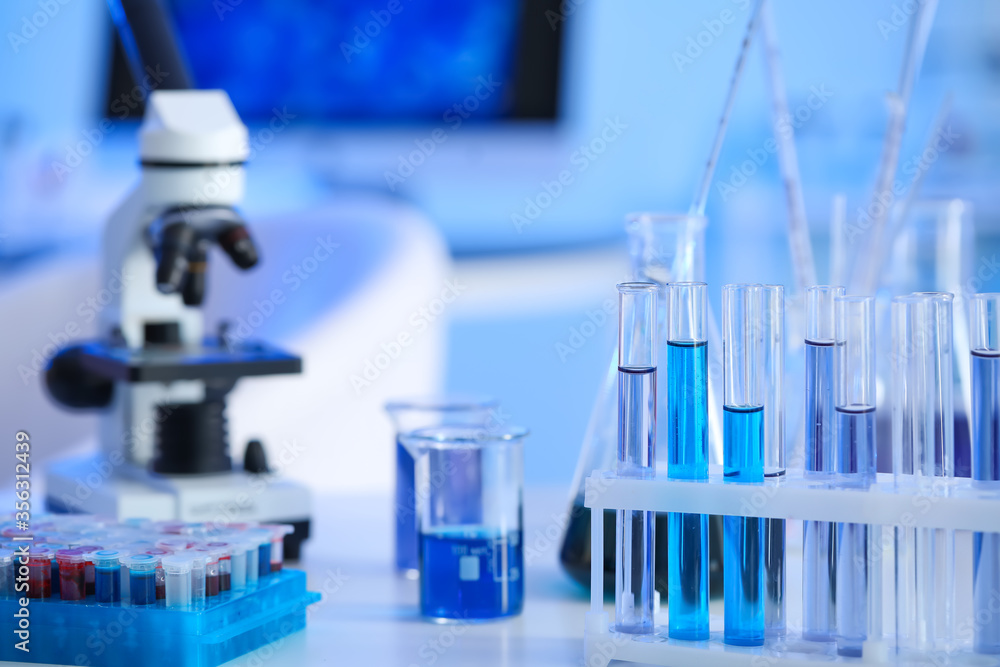 Microscope and glassware on table in laboratory Microscope and glassware on table in laboratory