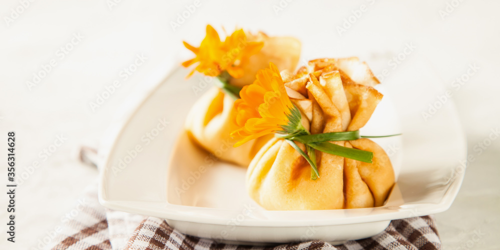 pancake sacks with a cottage cheese and fruit stuffing in a plate on a table, selective focus, copy space