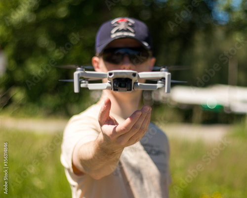 Small drone landing on operators hand.