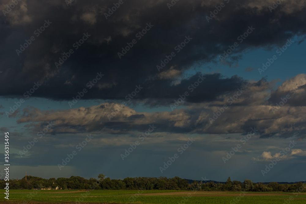 black clouds in the sky with a landscape