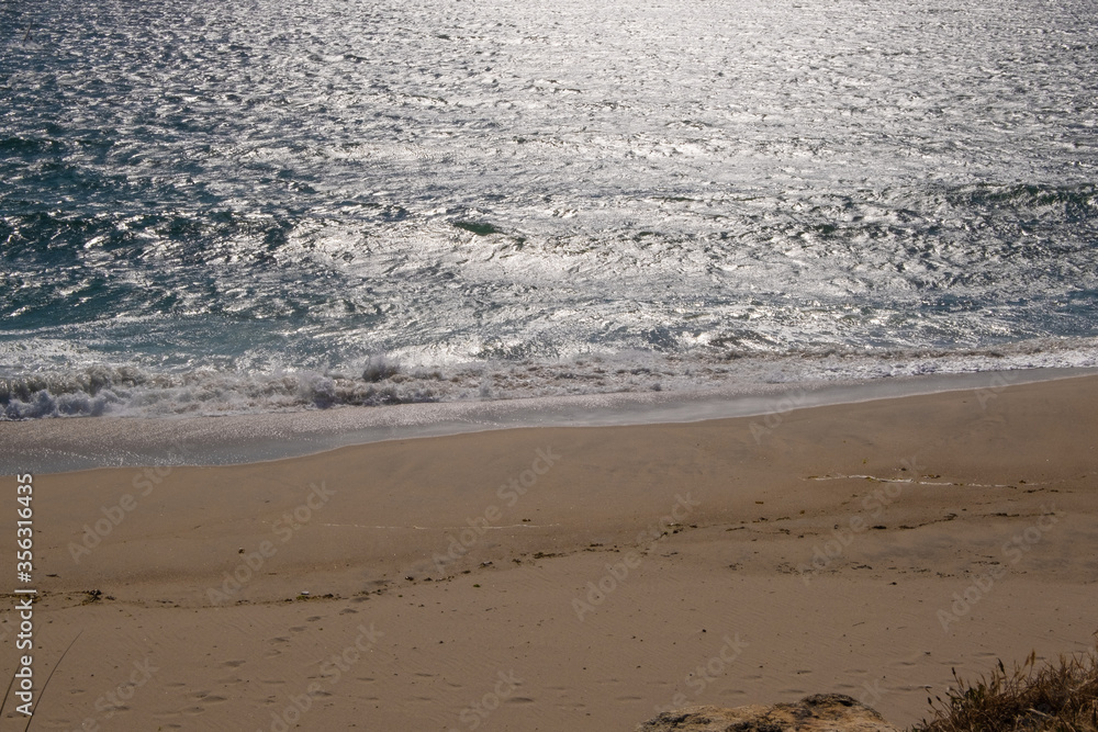 Empty beach at Vila do Conde Portugal in late afternoon with bright white reflections on water surface Empty beach at Vila do Conde Portugal in late afternoon with bright white reflections on water surface