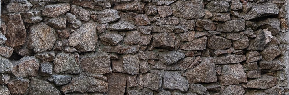 Old, rough stone wall made from rocks of different sizes. Wide background. Old, rough stone wall made from rocks of different sizes. Wide background.
