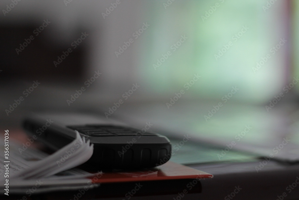 Close up of an old mobile phone and some data, papers. Close up of an old mobile phone and some data, papers.