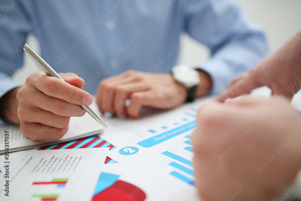 Group of people deliberate on problem with infographics closeup. White collar check money papers stock exchange market earnings list partnership agreement discussion concept Group of people deliberate on problem with infographics closeup. White collar check money papers stock exchange market earnings list partnership agreement discussion concept