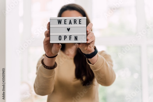 open again sigh on wooden table. local business reopen after quarantine covid-19 photo