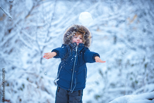 Winter landscape of forest and snow with cute child boy. Enjoying nature wintertime. Happy winter time. Well dressed enjoying the winter. photo