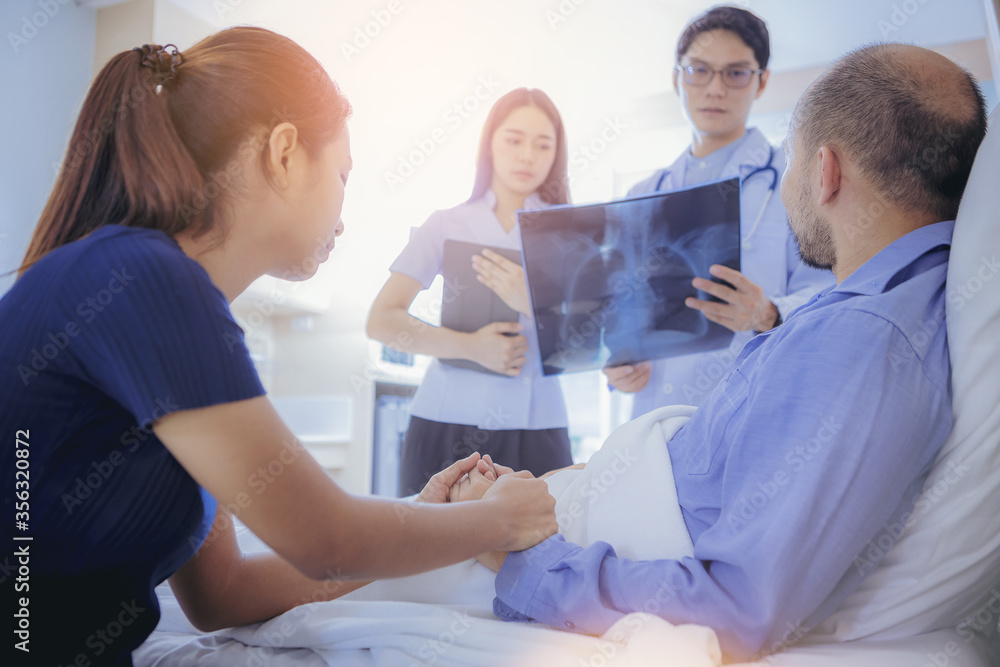 Obraz premium Doctor and nurse talk with husband patient about X-ray result , family health care , palliative care, with wife holding hand of patient at hospital