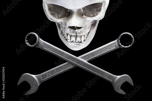 Two crossed wrenches or spanners and skull on black backgorund for concept design. Repair service. Service concept. Pirate sign, motorcycle repair, bikers concept.