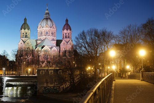 St. Lukas am Isar-Ufer zur blauen Stunde mit künstlicher Beleuchtung, München