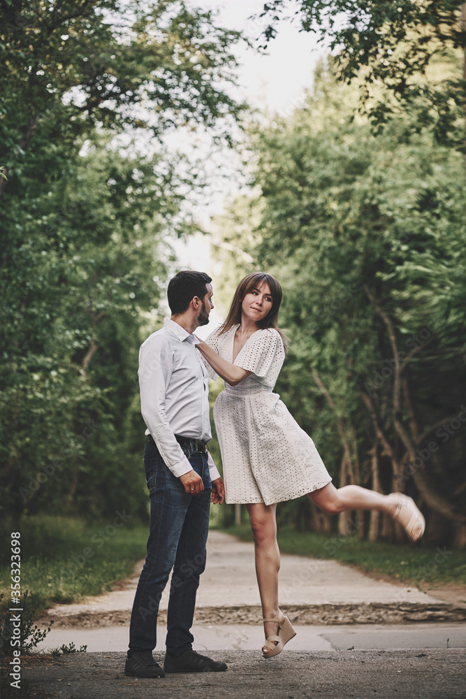 A guy and a girl are walking in the park. Romantic date evening walk. The relationship between people is love and tenderness.