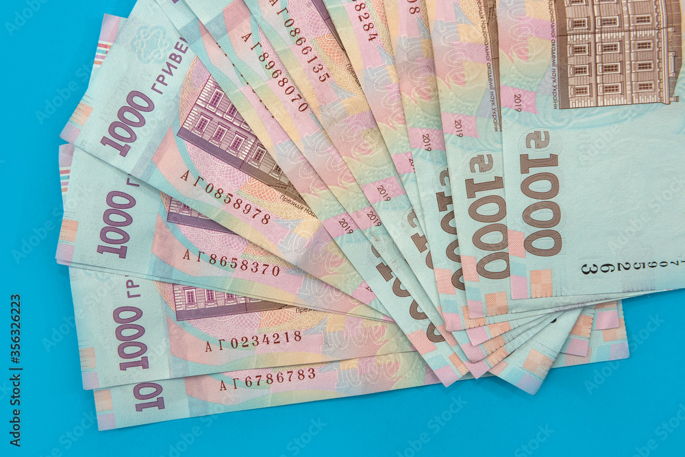 UAH. Money of Ukraine 1000 hryvnia, Ukrainian banknote isolated on blue UAH. Money of Ukraine 1000 hryvnia, Ukrainian banknote isolated on blue