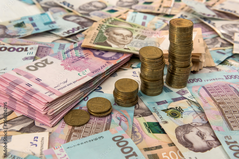 Close up coin stacked growing as financial chart lying on ukraine money as background. For business growth Close up coin stacked growing as financial chart lying on ukraine money as background. For business growth
