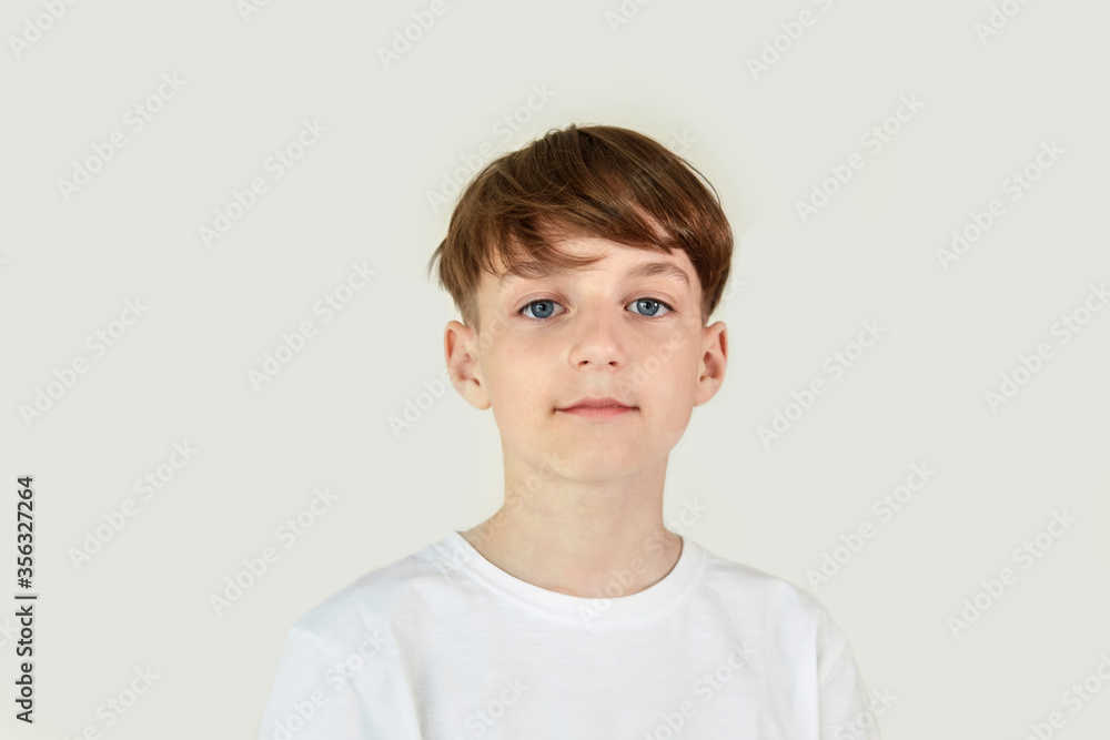 Beautiful cute boy in a white T-shirt on a white isolated background. Beautiful cute boy in a white T-shirt on a white isolated background.