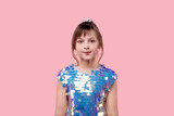 Sweet little girl in shiny dress. Hair is collected in a ponytail.