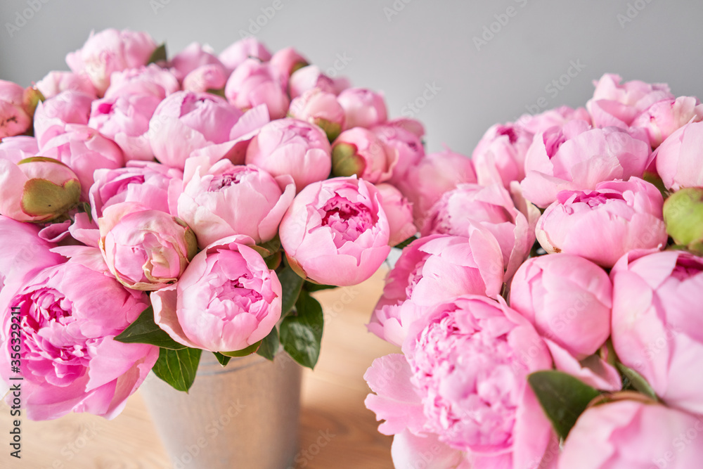 Two vases with peonies for Flowers delivery. Pink Angel Cheeks peonies in a metal vase. Beautiful peony flower for catalog or online store. Floral shop concept .