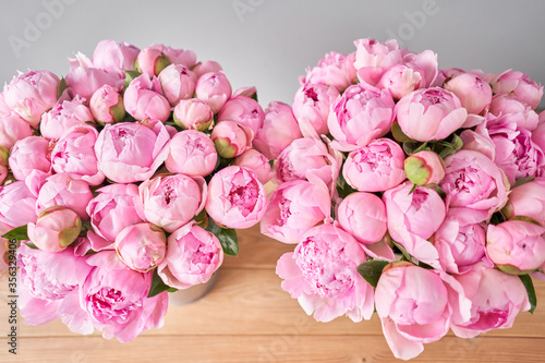 Two vases with peonies for Flowers delivery. Pink Angel Cheeks peonies in a metal vase. Beautiful peony flower for catalog or online store. Floral shop concept .