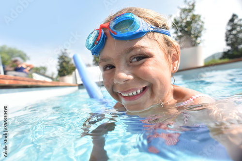 Little girl in private swiimming-pool wearing goggles