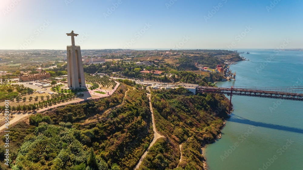 Aerial bridge on April 25th, across the Tejo River, statue of Jesus Christ Lisbon, Portugal. The longest bridge in Europe. Close-up. - obrazy, fototapety, plakaty 