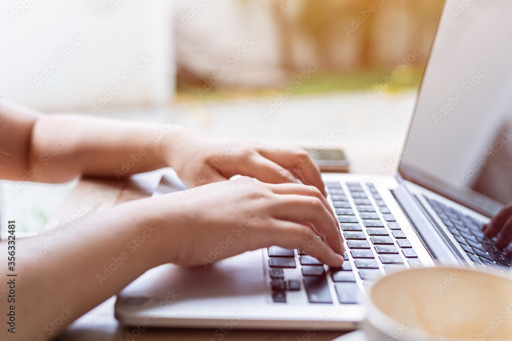 Close-up of freelance people business female casual working with laptop computer with coffee cup and smartphone in coffee shop like the background,communication concept Close-up of freelance people business female casual working with laptop computer with coffee cup and smartphone in coffee shop like the background,communication concept