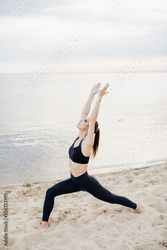 Yoga on a beach. Fitness model exercising outdoors. Concept of healthy lifestyle.
