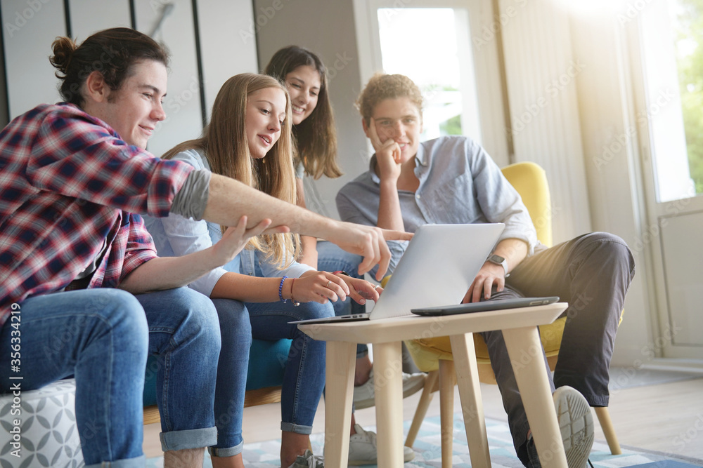 group of young people working on a laptop