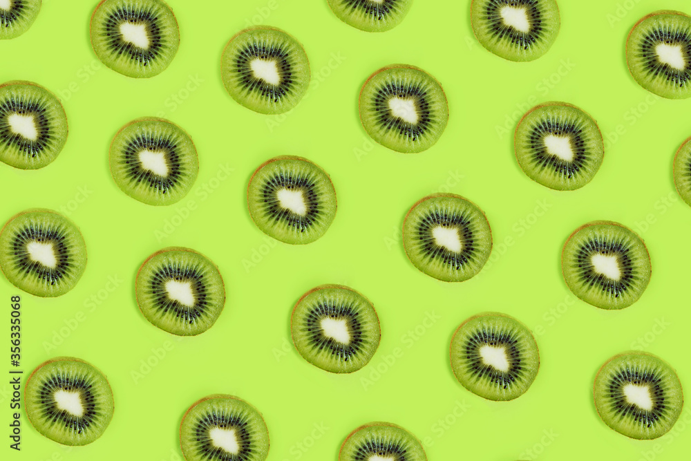 Creative color pattern of green kiwi fruit on a green background, flatlay, layout Creative color pattern of green kiwi fruit on a green background, flatlay, layout