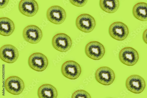 Creative color pattern of green kiwi fruit on a green background, flatlay, layout
