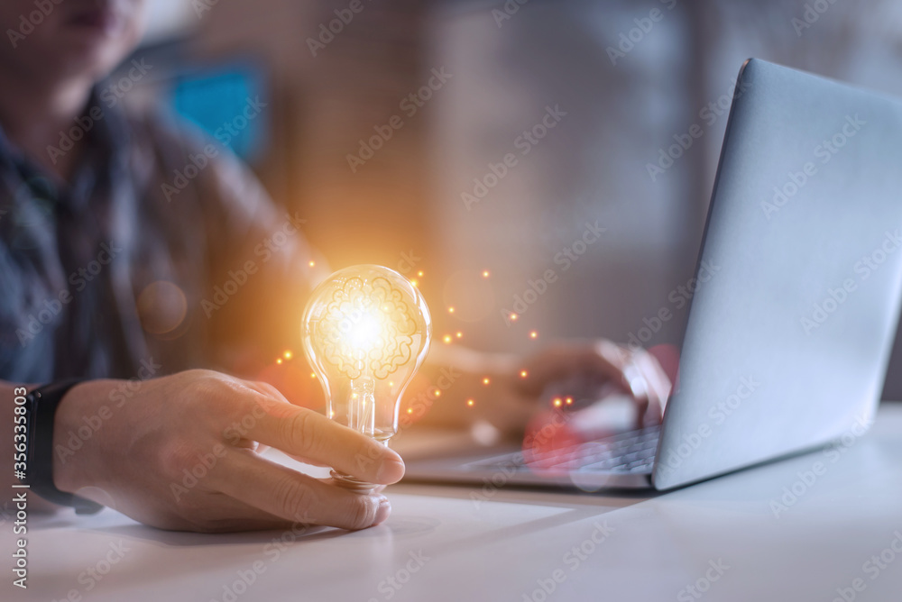© chartphoto - Business man holding light bulbs, ideas of new ideas with innovative technology and creativity,New ideas with innovation and creativity concept,