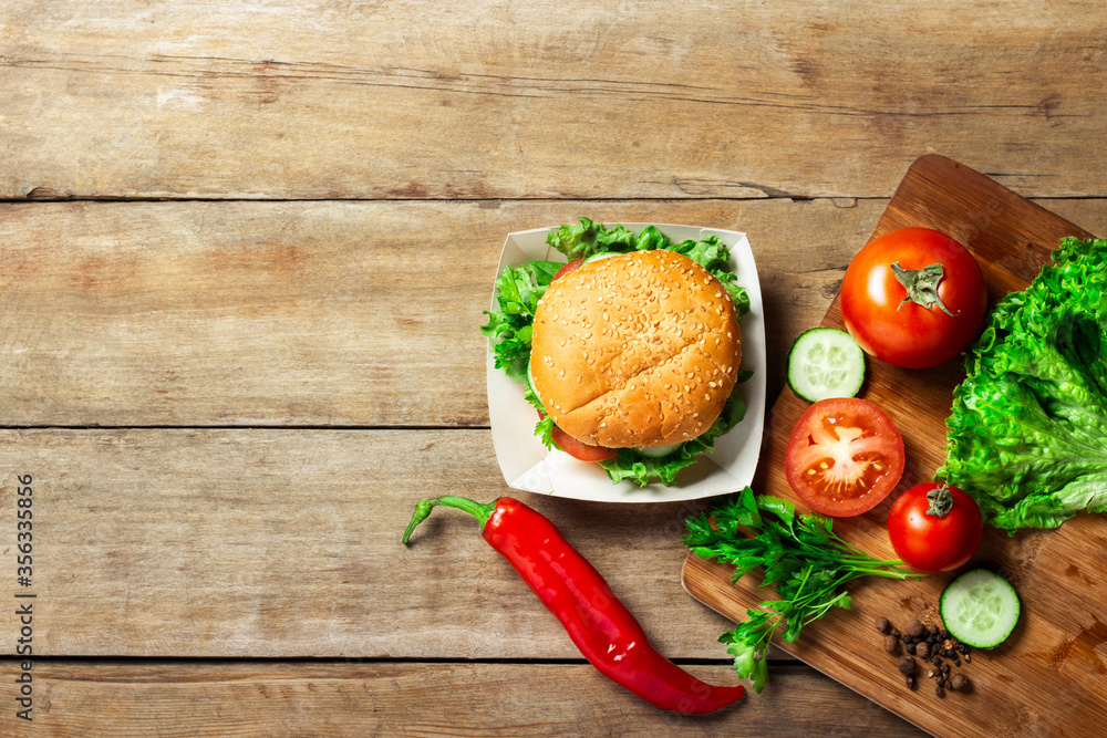 Vegetarian burger. Ingredients for a burger on a wooden background. Copy space, flat lay Vegetarian burger. Ingredients for a burger on a wooden background. Copy space, flat lay