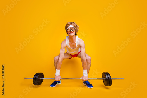Full length body size view of his he nice funky slim motivated desperate foxy guy lifting barbell doing work out coacher program isolated over bright vivid shine vibrant yellow color background photo