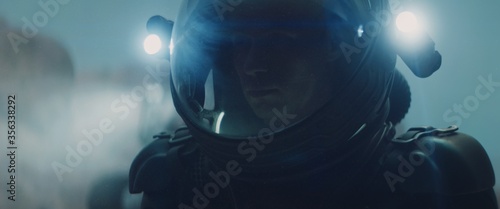 Caucasian male astronaunt checking hud on her suit while exploring planet surface, Mars colonization concept