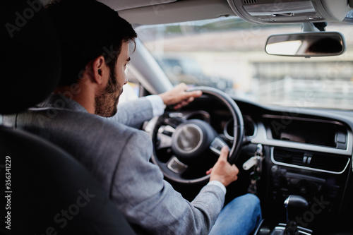Rear view of a young man looking straight while driving a car © Astarot