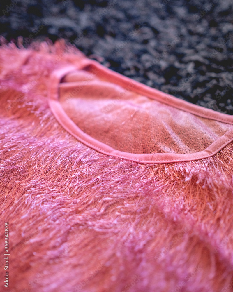 Close-up of pink hairy and sparkly shirt over black hairy background Close-up of pink hairy and sparkly shirt over black hairy background