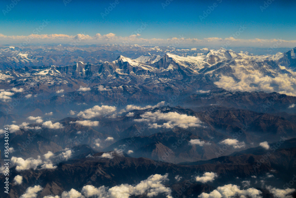 Aerial view of the Himalayas mountain ranges covered in snow and clouds