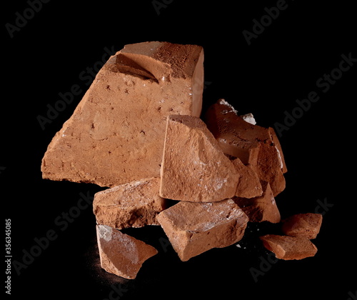 Broken brick pieces, chunks for bricklaying and construction isolated on black background