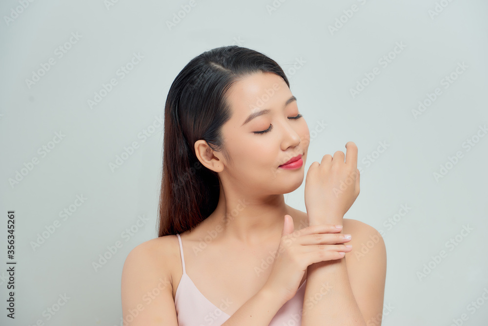 Smiling young woman applies cream on her hands Smiling young woman applies cream on her hands