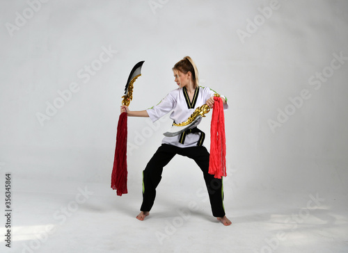 beautiful girl in a black and white kimono and with golden swords