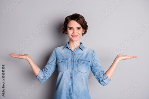 Photo of attractive lady hold open arms hands empty space showing nice offer two variants pick select best one wear casual denim shirt isolated grey color background photo