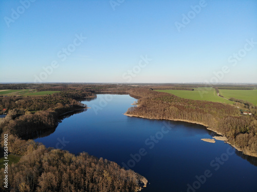 Fototapeta Naklejka Na Ścianę i Meble -  Aerial view of Lake Heinersdorfer See, located 40 kilometres east of Berlin near the B5 in Heinersdorf (Steinhöfel), It is divided by a road dam into the Small and Large Heinersdorfer See. 