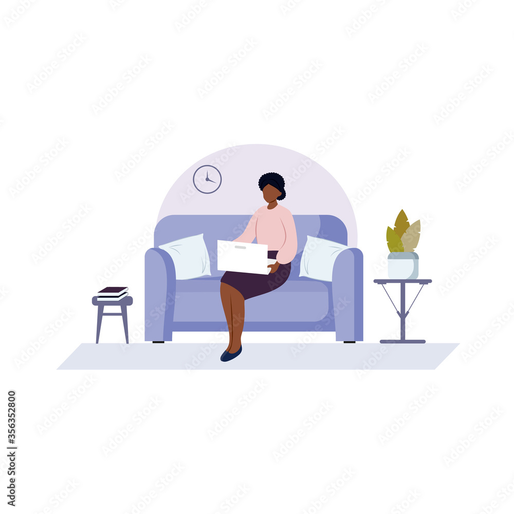 An African-American woman is sitting on the couch typing on a computer. A black girl works at home on a laptop. The concept of freelancing, working at home, and online learning.