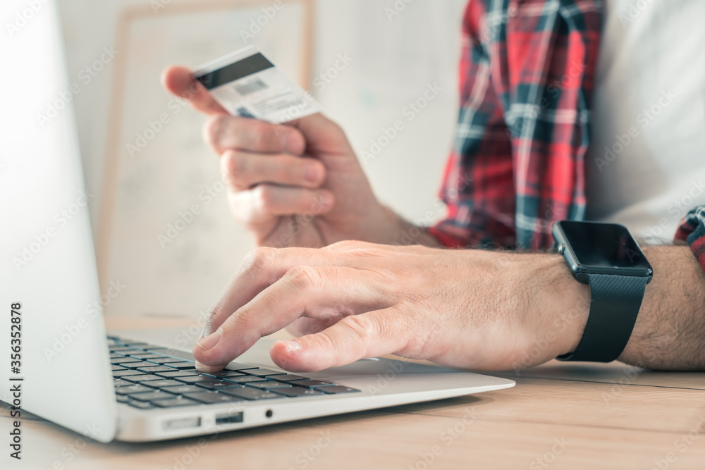 Freelancer shopping online with laptop computer and credit card Freelancer shopping online with laptop computer and credit card