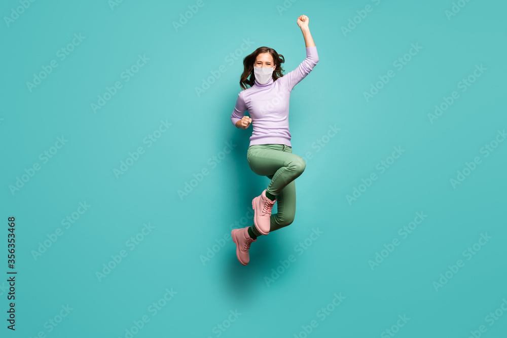 Full length body size view of her she slim lucky girl wearing safety gauze mask jumping sickness illness disease recovery decontamination isolated green blue teal turquoise color background
