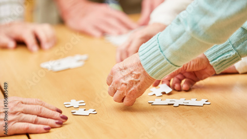 Wrinkled hands of seniors playing the puzzle