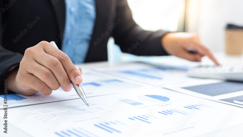 Marketing businessmen are analyzing financial and insights strategies for generating revenue including corporate income tax with laptops and graphs in the office, Finance and Accounting concept. Marketing businessmen are analyzing financial and insights strategies for generating revenue including corporate income tax with laptops and graphs in the office, Finance and Accounting concept.