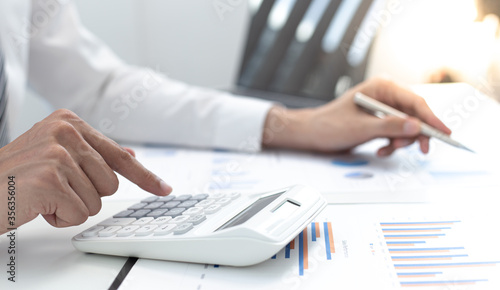 Businessman are calculating finances and analyzing market data with graphs and laptops at work, Business Financing Accounting Banking and tax system Concept.