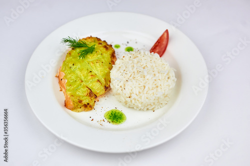 A white plate topped with rice meat and vegetables